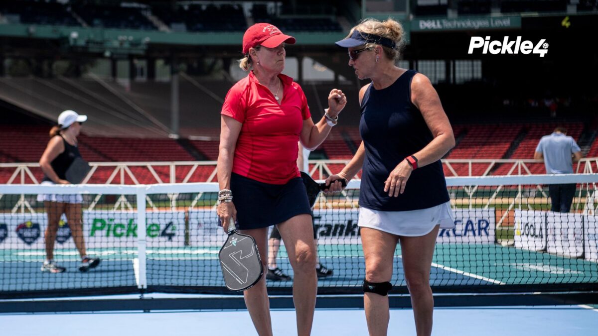 Two pickleball players talking on a pickleball court