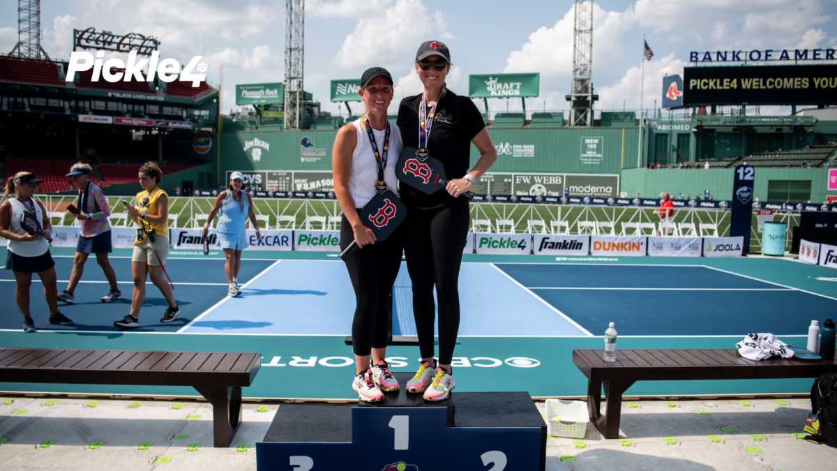 Pickleball players wearing gold medals and holding their pickleball paddles after winning a high-stakes tournament division